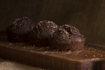 Chocolate muffins on a wooden platter