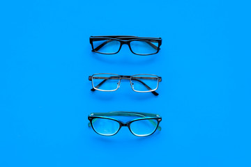 Glasses concept. Set of glasses with different eyeglass frame and transparent lenses on blue...