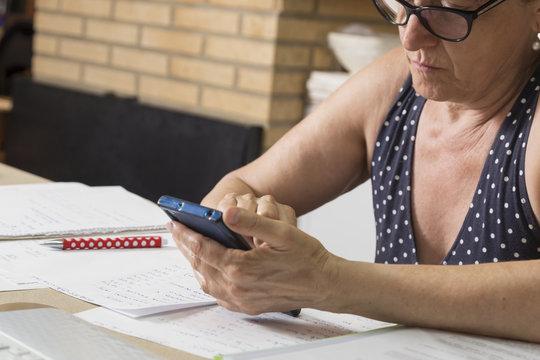 looking at the mobile phone on the work table