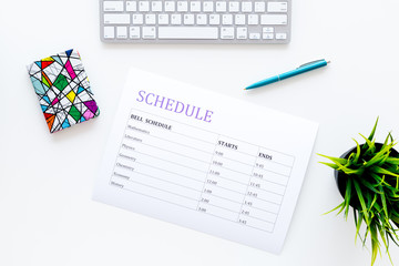 College or school schedule with lessons and bell time. Student planner on white work desk with computer and pen top view