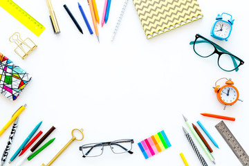 Fototapeta premium Education background, frame. School, student, office supplies. Stationery, glasses, alarm clock, notebook on white background top view copy space