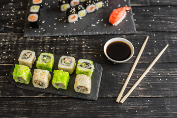 Fresh and tasty sushi on dark background. It can be used as a background