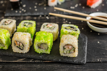 Fresh and tasty sushi on dark background. It can be used as a background