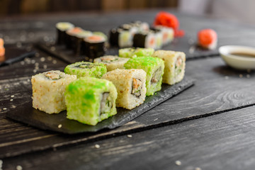 Fresh and tasty sushi on dark background. It can be used as a background