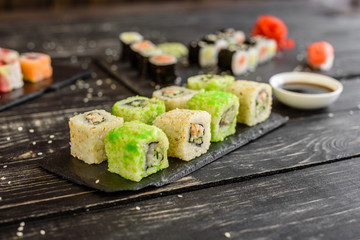 Fresh and tasty sushi on dark background. It can be used as a background