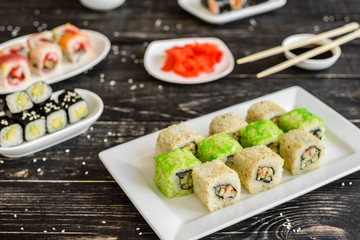 Fresh and tasty sushi on dark background. It can be used as a background