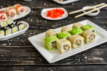 Fresh and tasty sushi on dark background. It can be used as a background