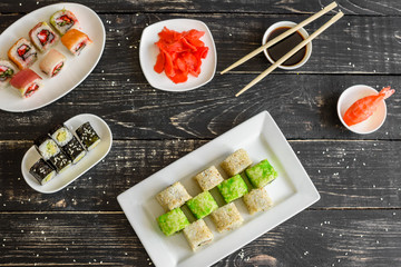 Fototapeta na wymiar Fresh and tasty sushi on dark background. It can be used as a background