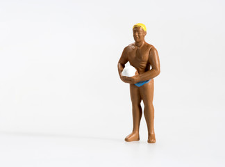 Miniature man in trunks playing volleyball