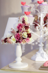 Table lamp decorated with flowers and desserts.