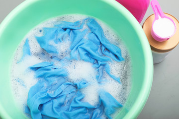 Color clothes with foam in basin, top view