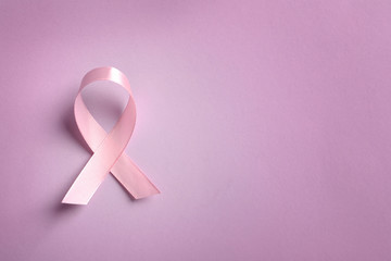 Pink ribbon on color background, top view. Cancer awareness