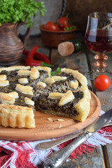 Homemade pie with mushrooms and herbs. Quiche on wooden background. Vegetarian food.