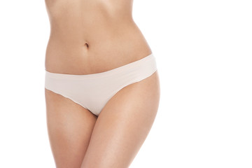 Young woman showing smooth skin after bikini epilation on white background © New Africa