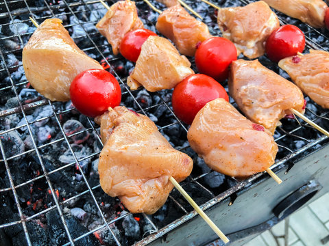 Barbecue of chicken meat with vegetables on the coals. Chicken skewers with grilled vegetables 