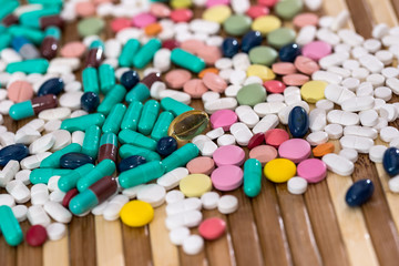 Colourful tablets dispersed on wooden table closeup