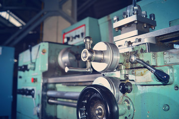 Fototapeta premium Tokarka, obróbka metali poprzez cięcie na urządzeniach przemysłowych. Przyciemniony obraz.