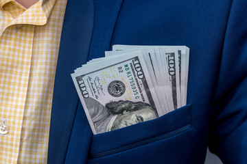 American dollar banknotes in businessman jacket's pocket