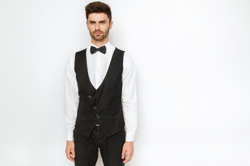 Strong commercial male model face in tuxedo on white background
