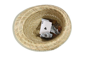 Straw hat and money with playing cards on a white background