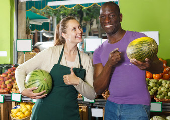 Fototapeta premium Seller and positive client holding watermelon
