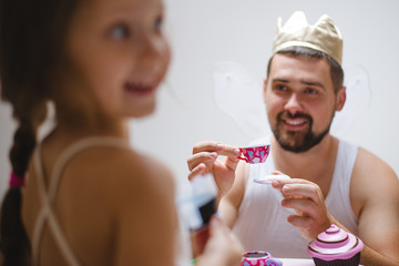 Little daughter and father have fun, dressing in princess costume, daddy makeup