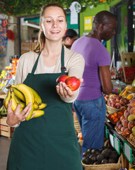 Fototapeta premium Happy seller helping client choose fruits