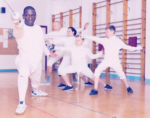 African American wearing fencing uniform practicing with foil