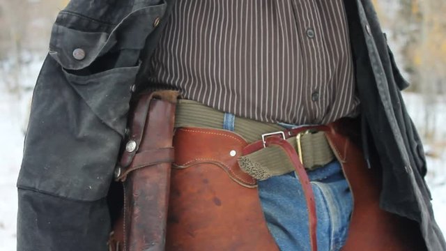 Old western revolver pistol under a cowboys jacket. 
