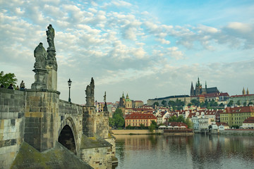 Obraz premium Charles Bridge in Prague with sculptures, against the background of a cloudy morning sky