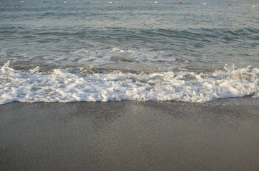 view of sea waves, water drops and wet sand