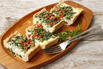 Tart from ricotta with chervil and vegetables, cut into pieces.