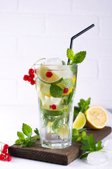 Various berry lemonade or mojito cocktails, fresh iced lemon lime , Red currant infused water, summer healthy detox drinks light background