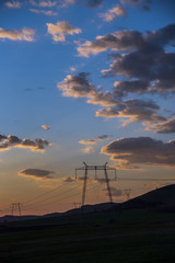 Obraz premium pylon power turbines at sunset