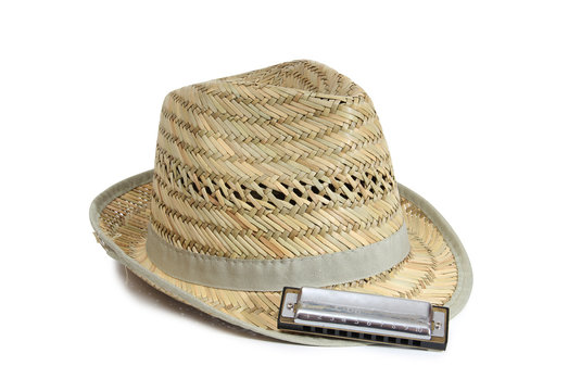 Harmonica and straw hat on a white background