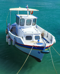 Traditional white blue wooden fishing boat at the harbor
