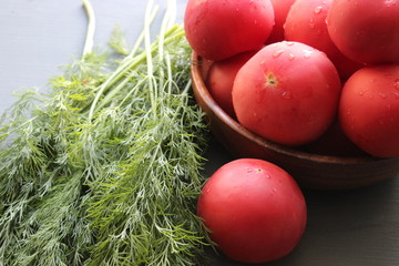 Fresh red ripe tomatoes and fresh dill greens for salad making, close-up