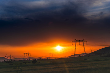 Obraz premium Electric pylons and clouds at the sunset