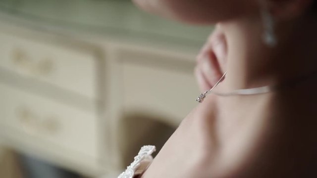 Young sexy woman put on necklace indoors