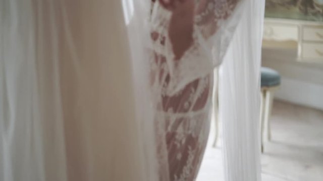 Young sexy bride woman in lingerie and veil walking