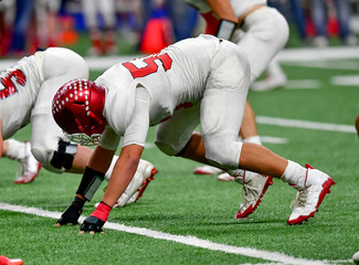 Football lineman blocking and rushing during a football game
