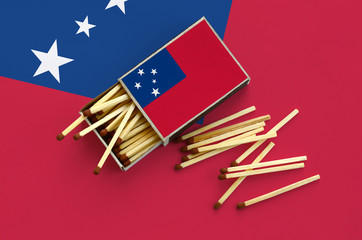 Samoa flag  is shown on an open matchbox, from which several matches fall and lies on a large flag
