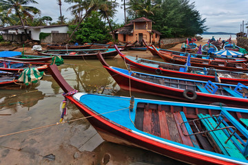 Fototapeta na wymiar Boats in the tropical sea under gloomy dramatic sky