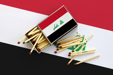 Iraq flag  is shown on an open matchbox, from which several matches fall and lies on a large flag