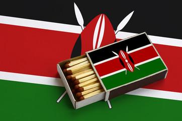 Kenya flag  is shown in an open matchbox, which is filled with matches and lies on a large flag