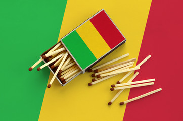 Mali flag  is shown on an open matchbox, from which several matches fall and lies on a large flag
