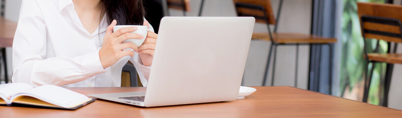 Closeup banner website asian young woman working online on laptop at coffee shop, professional...