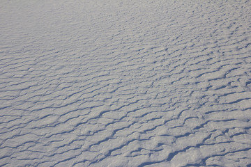 Background drift snow waves were made by the wind at winter snowstorm