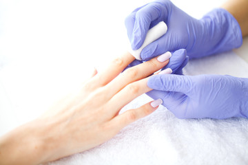 Obraz na płótnie Canvas SPA manicure. French manicure at spa salon. Woman hands in a nail salon receiving a manicure procedure. Manicure procedure
