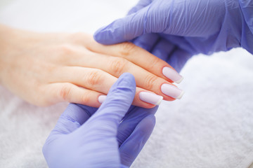 SPA manicure. French manicure at spa salon. Woman hands in a nail salon receiving a manicure procedure. Manicure procedure